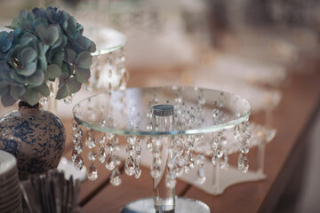 Table with plates stands for candy bar, catering. Decorating an event in restaurant. Wedding hall...