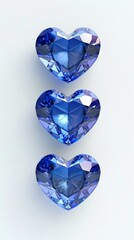Fototapeta premium Three blue heart-shaped gemstones on white background, arranged vertically. Jewelry and luxury concept