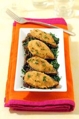 Stuffed mussels on spinach and mushrooms.