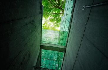 Eco-friendly building in modern city. Sustainable glass office building with trees for reducing...