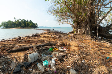 Plastic bottles and face mask lie on the beach and pollute the sea and marine life. Garbage rubbish...