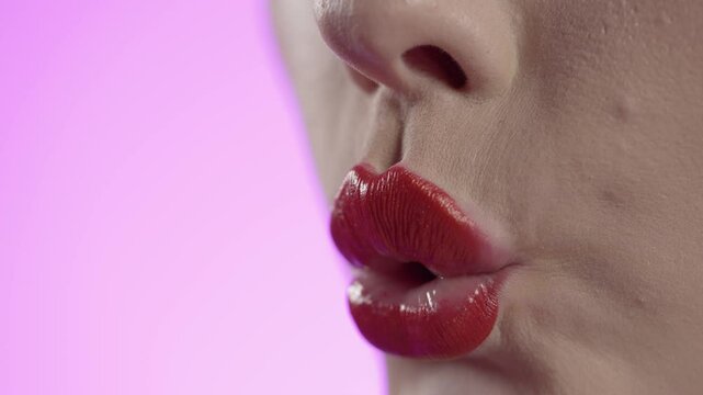Close Up Of Sexy Woman's Lips With Red Lipstick Blowing Kiss With Pink Nail Polish Hand, Studio Shot