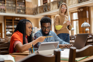Team of students looking involved and interested while working in the library