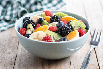 Fruit salad in a blue bowl on wooden table