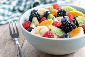 Fruit salad in a blue bowl on wooden table
