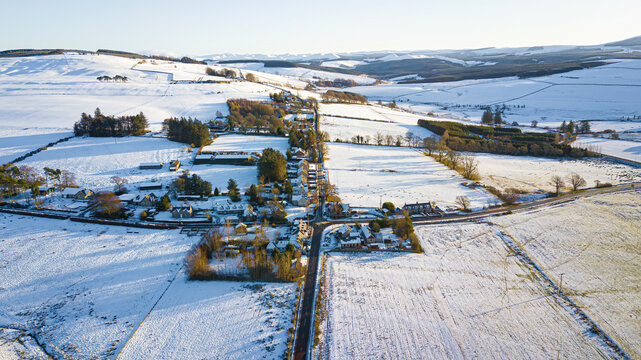 Aerial view of snowy village and fields in Chesters, Hawick, Scotland, United Kingdom.