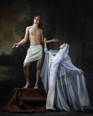 Divine Encounter. Shirtless man draped in white cloth stands on pedestal, arms outstretched, as...