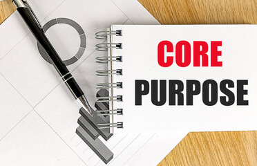 CORE PURPOSE text on notebook with chart on wooden background