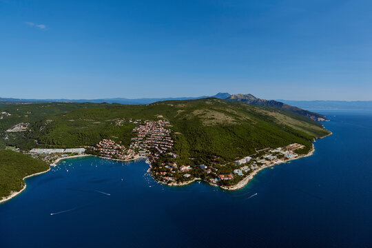 Aerial view of tranquil bay and coastline with mountains and forest in Rabac, Istria, Croatia.