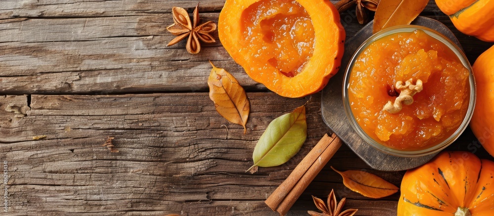 Poster A tempting bowl of pumpkin jam with its ingredients displayed on a wooden surface in a top view layout, allowing for text in the open area of the image. Copy space image