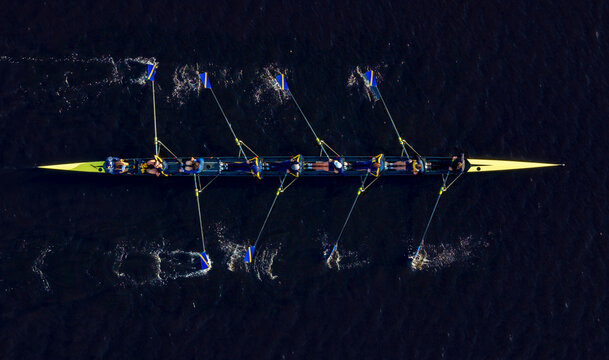 Aerial view of synchronized kayaking team in action on dark water, Boston, Massachusetts, United States.