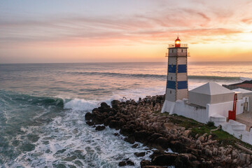 Aerial view of Lighthouse by the ocean at sunset, Cascais, Portugal.