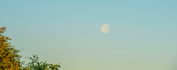 Moon orbiting planet earth at sunrise in summer, Almere, Flevoland, Netherlands, June 24, 2024