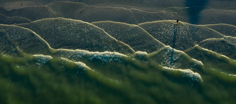 Aerial view of serene beach with walking person and calming waves, Pass-A-Grille, Florida, United States.