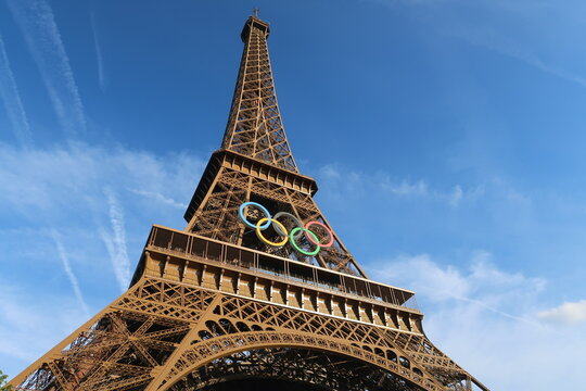 La tour Eiffel orn&eacute;e des anneaux olympiques, c&eacute;l&egrave;bre logo symbole des Jeux olympiques, pour les JO d&rsquo;&eacute;t&eacute; de Paris 2024, sous un ciel bleu &ndash; juin 2024 (France)