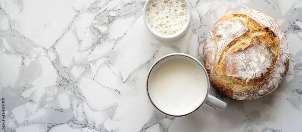 Aufkleber top view image showcasing a white round bread placed alongside a mug of milk on a marble surface, wi