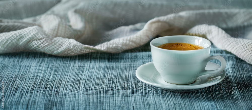 Aufkleber A coffee cup displayed on a textile surface with a blank area for additional visuals, such as text or images - copy space image.