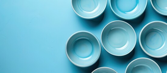 Light blue background with empty ceramic bowls, providing plenty of copy space for text.