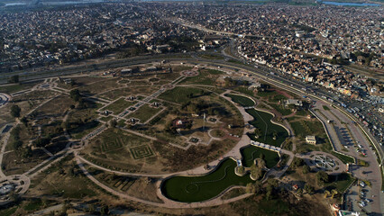 Aerial view of historic city park with dense housing and urban greenery, Lahore, Pakistan.
