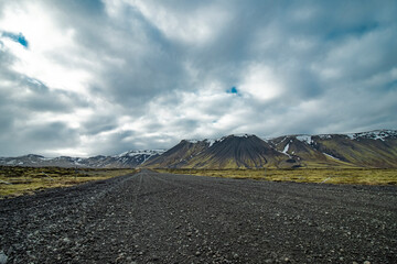 View of snow capped peaks and dramatic sky, leidarendi, iceland.