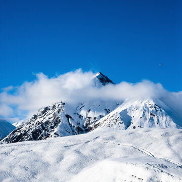View of Snow-Covered Caucasus Mountains under Clear Blue Sky, Gudauri Ski Resort, Georgia.