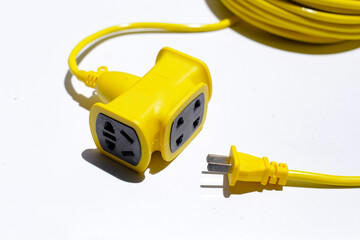 Yellow electric power cable with plug and socket on white background.
