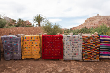 View of vibrant traditional carpet market in desert village, Ait-Ben-Haddou, Morocco.