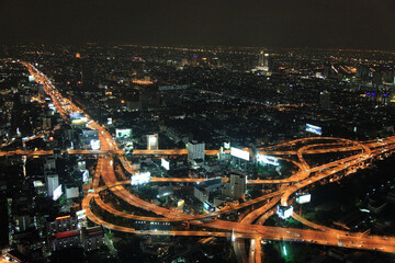 View of urban night cityscape with highway traffic and skyscrapers, Bangkok, Thailand.