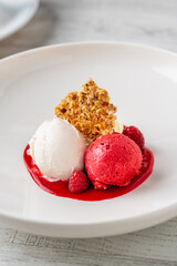 Raspberry and cream ice cream in a white porcelain bowl