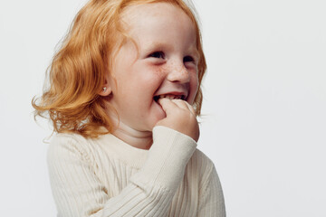 Redhaired girl gazing thoughtfully at the horizon against a simple white background