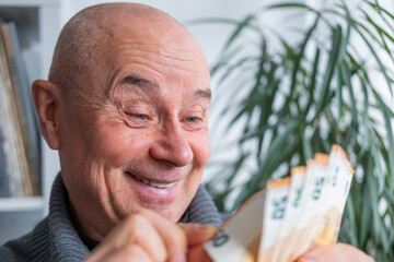 satisfied man holding euros, euro money, counting bills, rejoices in success, anticipates what to...