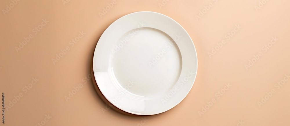 Poster top-down view of a blank white plate against a beige surface with ample space for text or images, id