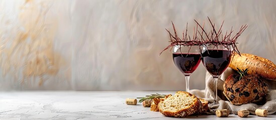 Crown of thorns, wine cup, and bread displayed on a white background with copy space image.