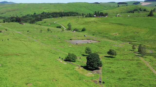 Aerial view of vibrant green hills and countryside, Hawick, Scotland.