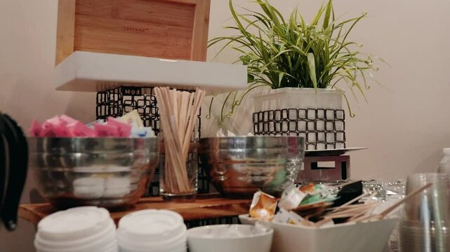 Hotel coffee station setup with cups, condiments, stirrers, and a coffee carafe, providing a convenient beverage area for guests.