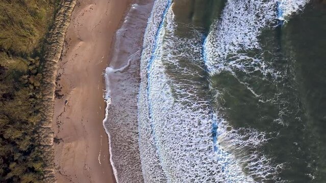 Aerial view of serene Scottish beach with remote shoreline and tranquil waves, North Berwick, Scotland.