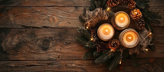 Top view of an advent wreath with two lit candles atop an antique wooden table, creating a cozy ambiance in the copy space image.