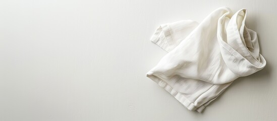 A white kitchen napkin, folded on a table, offers copy space in a minimalistic top view image.