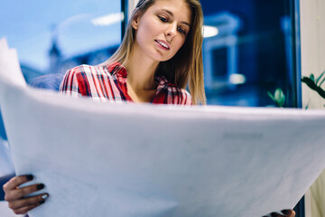 Skilled female architect checking drawing for drafting creative project analyzing graphic details...