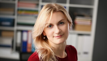 Portrait of young blonde woman on background of folders with documents. Work as secretary concept