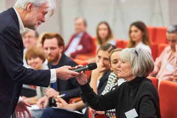 Speaker asking audience during business event in auditorium