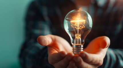 hand holding glowing light bulb, conceptual image of new ideas, innovation, and inspiration.
