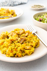 Stewed rice with chicken breast and mixed salad with radishes and various seeds, a served table with food, a delicious hearty lunch or dinner