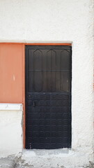 Black Patterned Door White Textured Wall Frontal Close-Up Photo