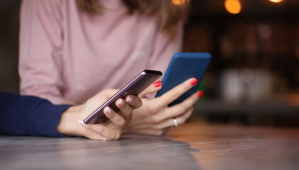 Two smartphones in female hands. Chatting concept