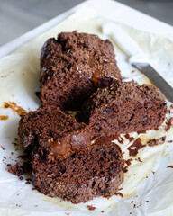 Chocolate cake cut into pieces lying on baking parchment. Clouse-up Chocolate cake slice.