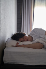 Young Woman Sleeping Peacefully in Bed by Window