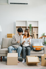 Happy asian young attractive couple man and woman with big boxes moving into a new house, new apartment