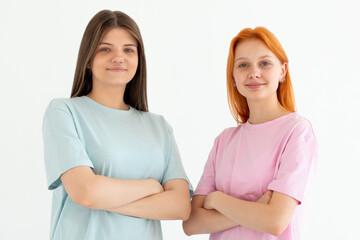 Young friends two women they wear blue and pink t-shirt casual clothes together hold hands crossed folded isolated on white background. Lifestyle concept