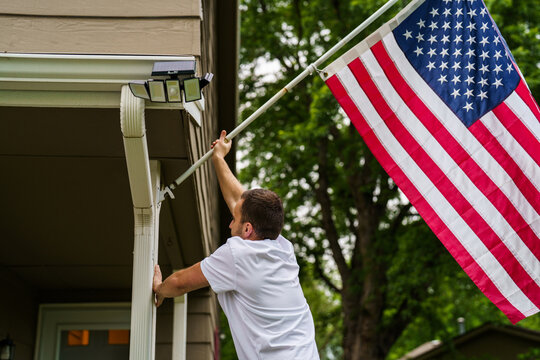 Young man put USA flag on his resedential area at house